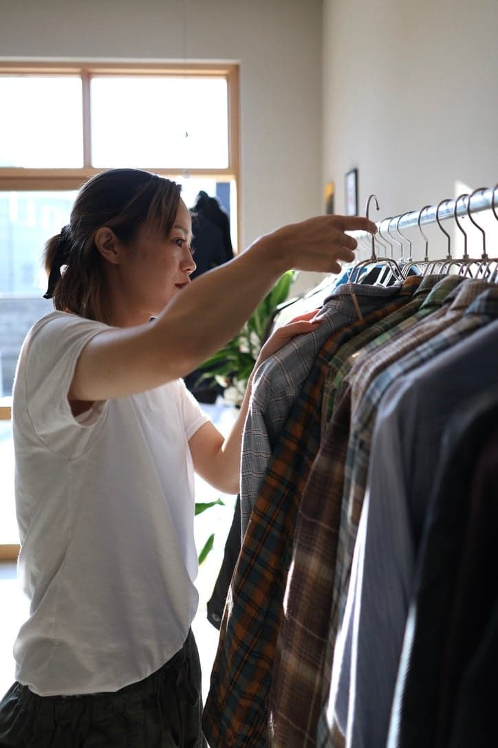 店内のラックで服を選ぶスタッフ